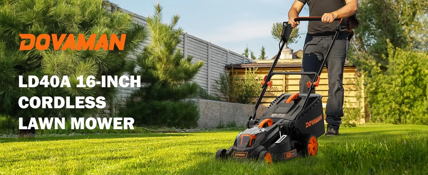 Person using a Dovaman cordless lawn mower on a grassy area with trees and a building in the background.