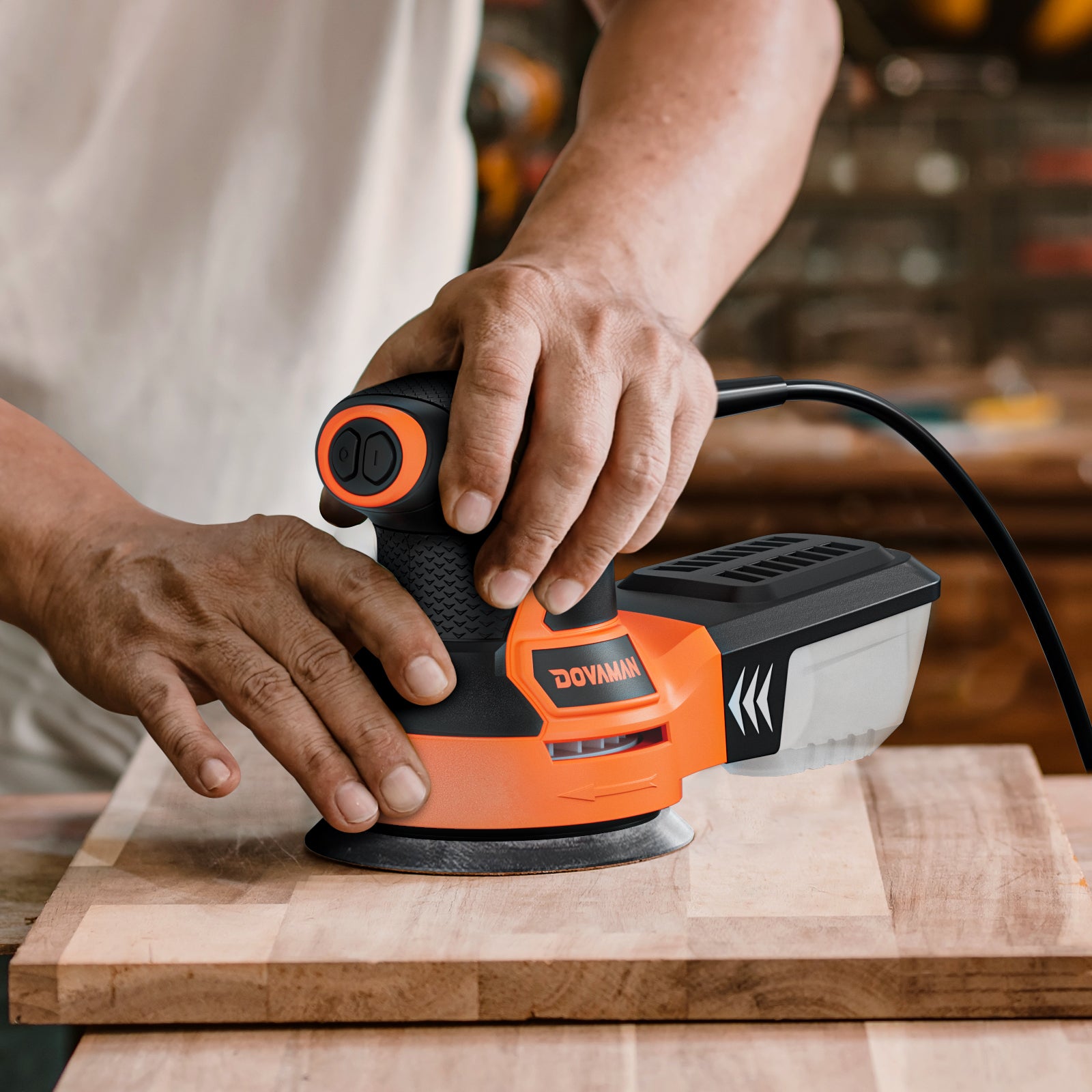 Person using a DOVAMAN power sander on a wooden surface